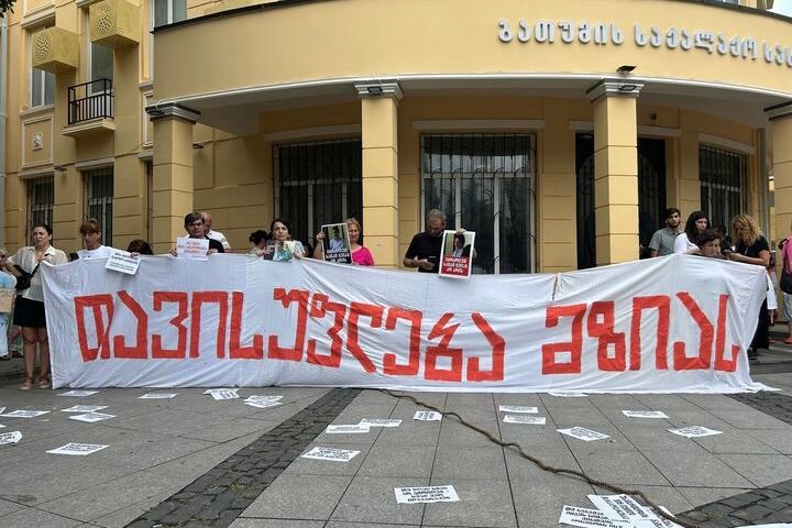 The facade of <em>Batumelebi’s </em>office in central Batumi displays a poster in support of Mzia Amaghlobeli, alongside the Georgian and EU flags. Photo: Givi Avaliani/OC Media.